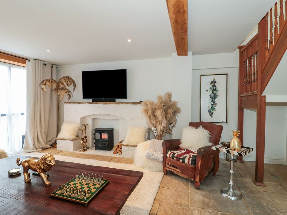 A living room with a fireplace and chessboard at The Sty near Malmesbury