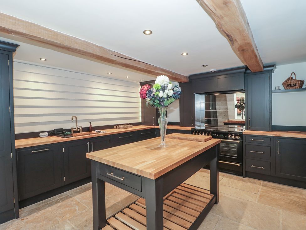 A kitchen with a central island and cabinets at The Sty Shades Farm near Malmesbury