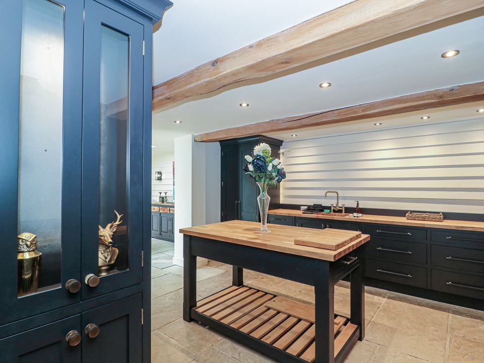 A kitchen with an island and cabinets at The Sty in Shades Farm near Malmesbury
