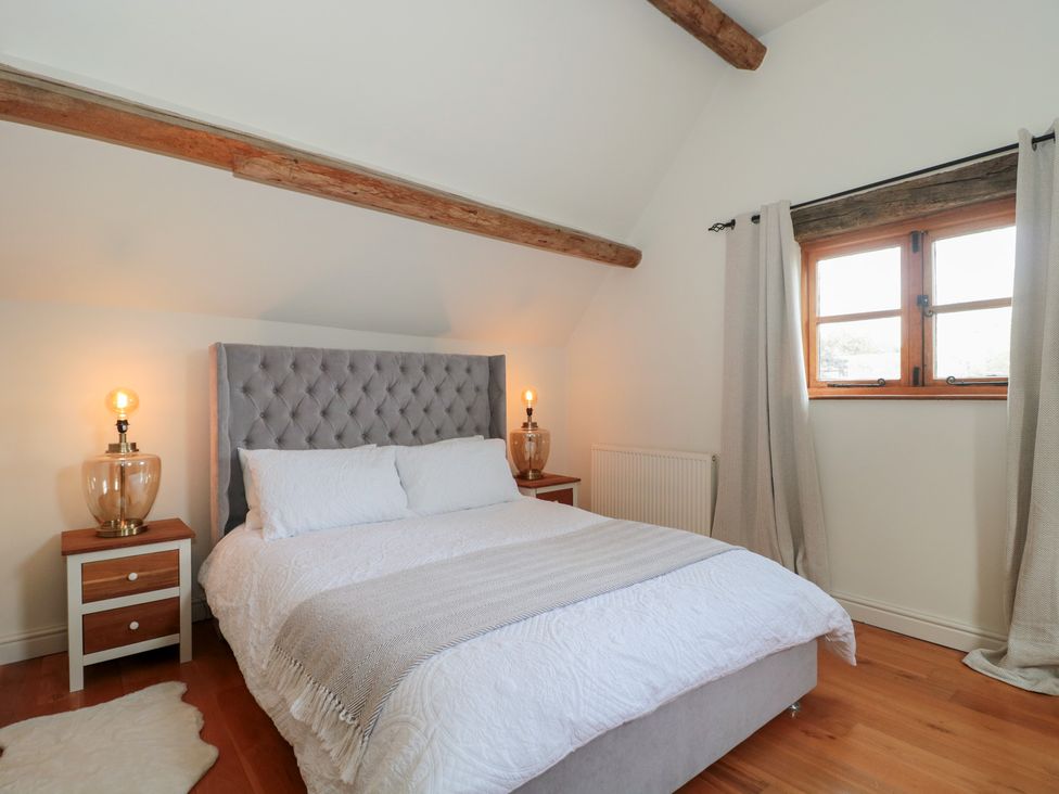 A bedroom with a bed and bedside tables at The Sty near Shades Farm