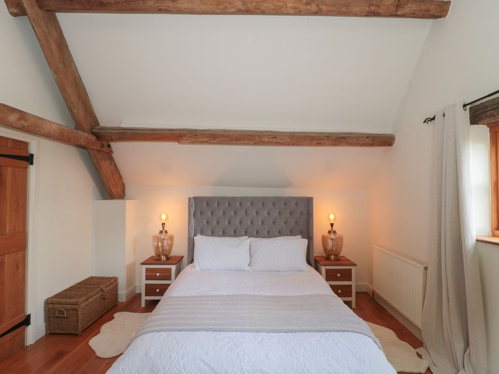 A bedroom with a bed and nightstands at The Sty Shades Farm near Malmesbury