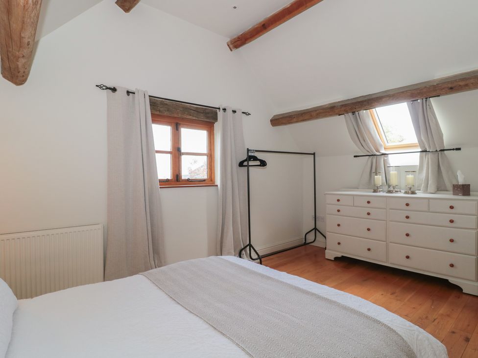 A bedroom with a bed and dresser at The Sty near Malmesbury