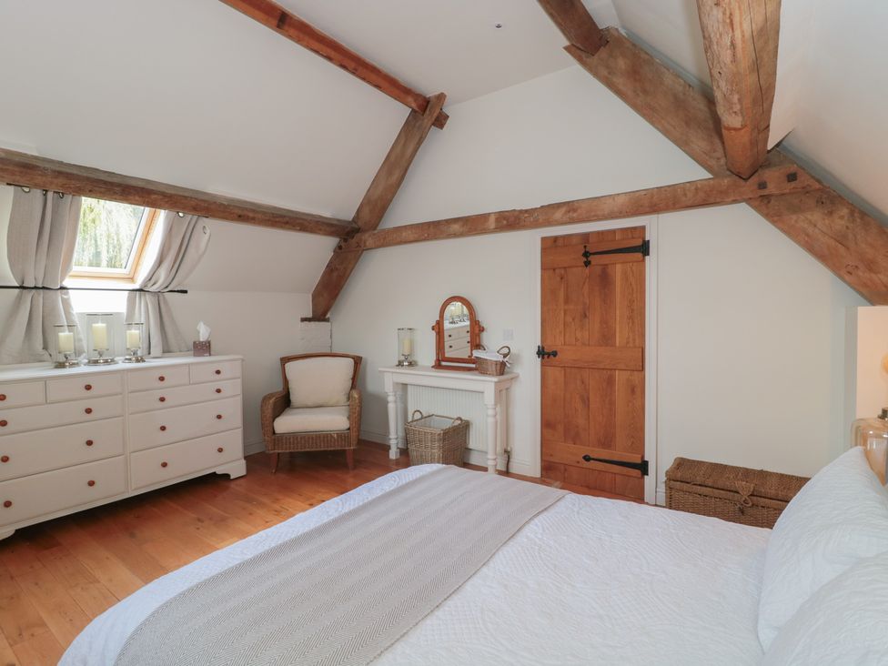 A bedroom with a bed and dresser at The Sty Shades Farm near Malmesbury