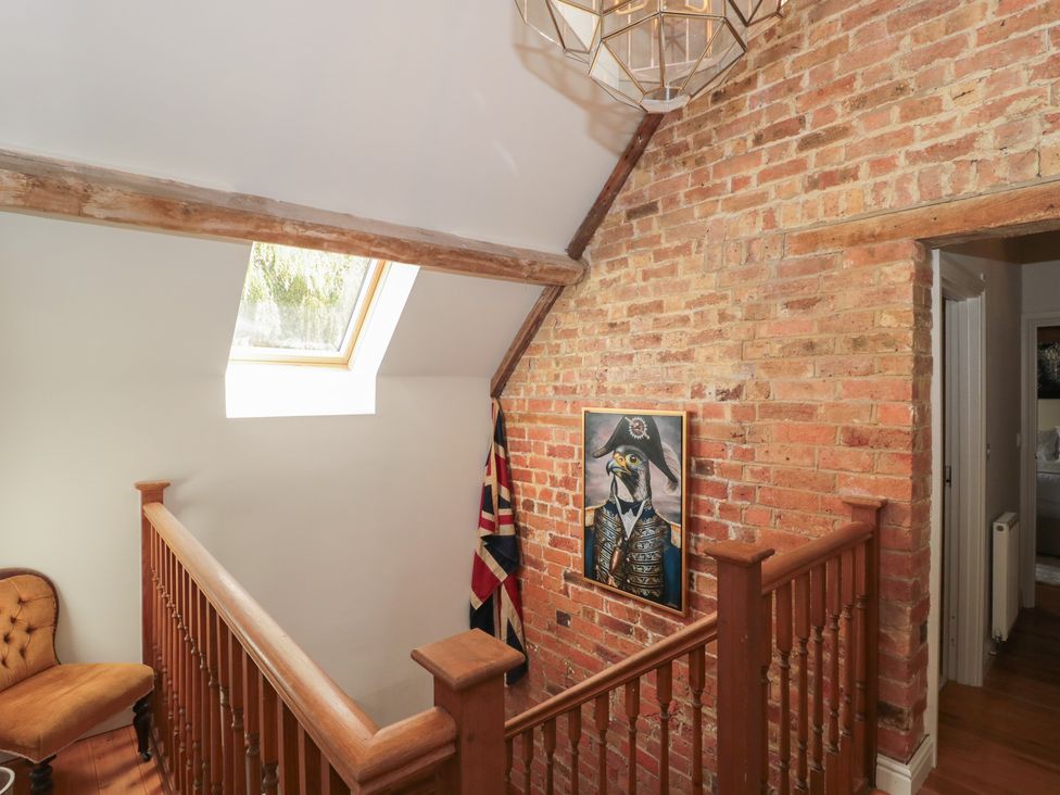 A hallway with a staircase and a window at The Sty near Shades Farm Malmesbury