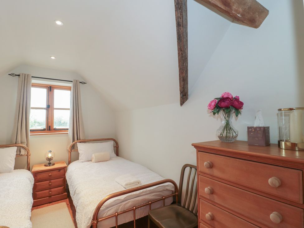 A bedroom with two beds and a dresser at The Sty Shades Farm near Malmesbury