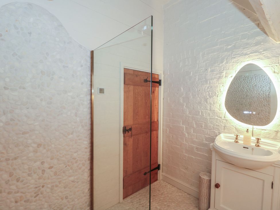A bathroom with a shower, sink, and mirror at The Sty, Shades Farm near Malmesbury