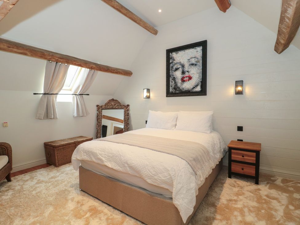 A bedroom with a bed and mirror at The Sty Shades Farm near Malmesbury