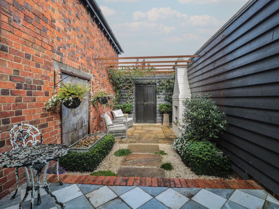 A garden with plants and a seating area at The Sty in Shades Farm near Malmesbury