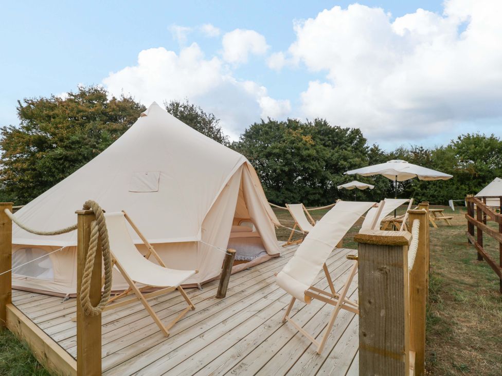 An outdoor area with a bell tent and sun loungers at Bell 1 Shades Farm near Malmesbury