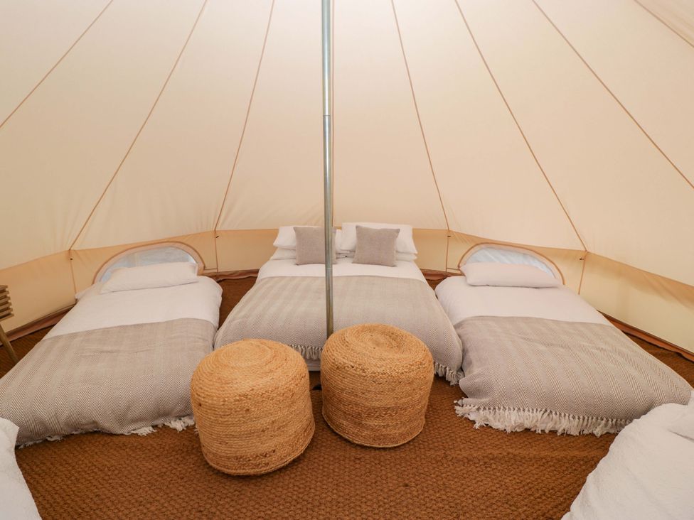 A tent with beds and stools at Bell 1 Shades Farm near Malmesbury