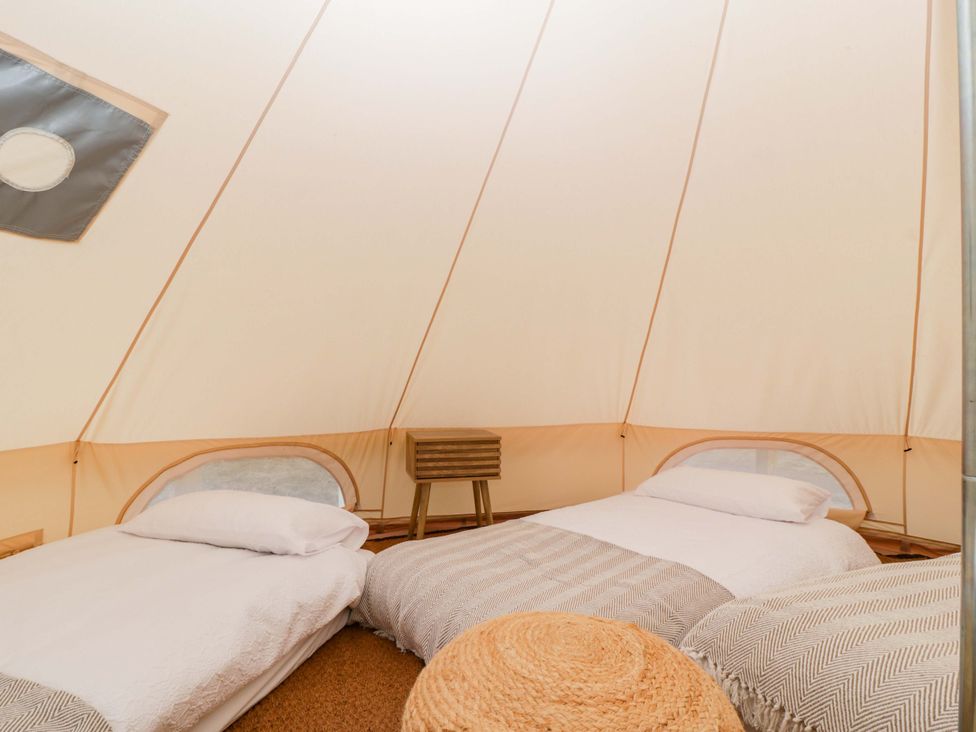 A tent with two beds and a table at Bell 1 Shades Farm near Malmesbury