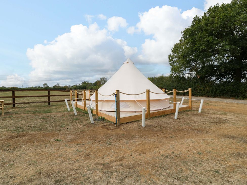 A bell tent on a wooden platform in an open field at Bell 1 near Shades Farm near Malmesbury