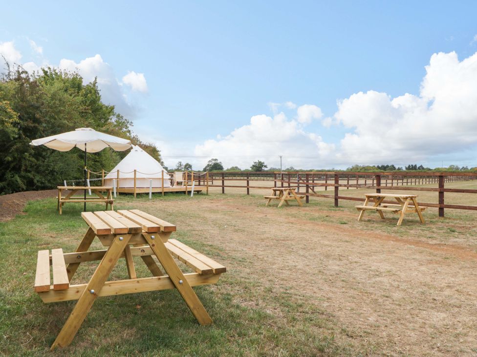 An outdoor area with picnic tables and a yurt at Bell 1, Shades Farm near Malmesbury