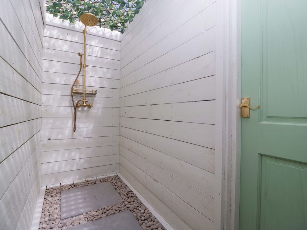 A shower area with a brass shower head at Bell 1 Shades Farm near Malmesbury