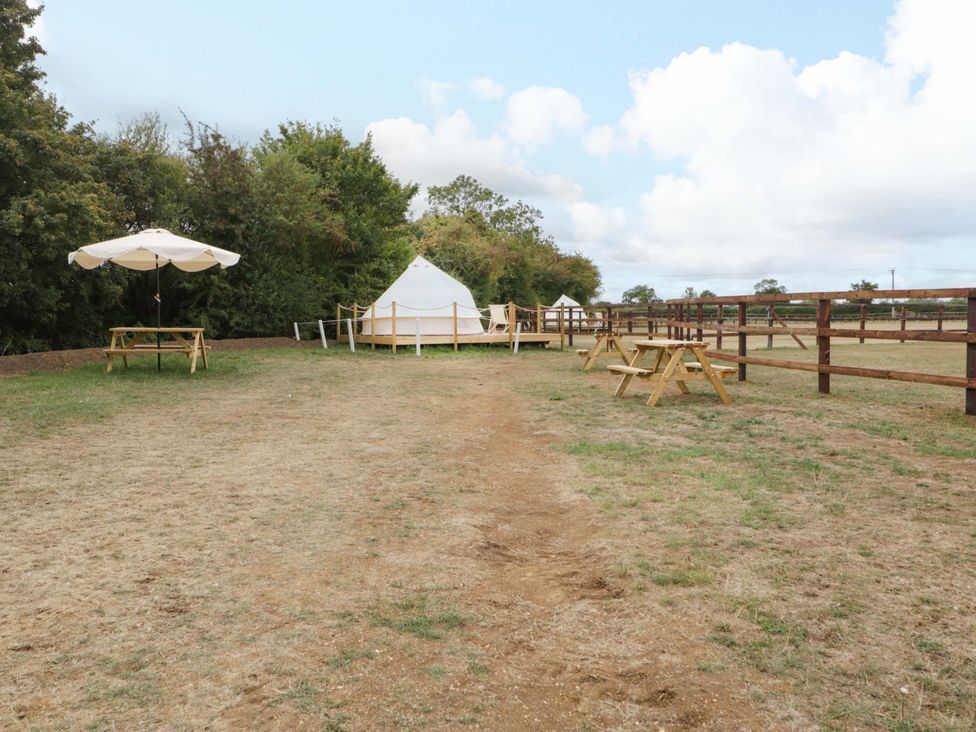 An outdoor area with a tent, table, and umbrella at Bell 1, Shades Farm near Malmesbury
