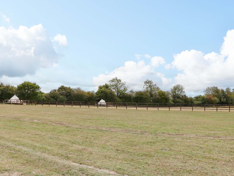 An outdoor space with tents and a fence at Bell 1, Shades Farm near Malmesbury