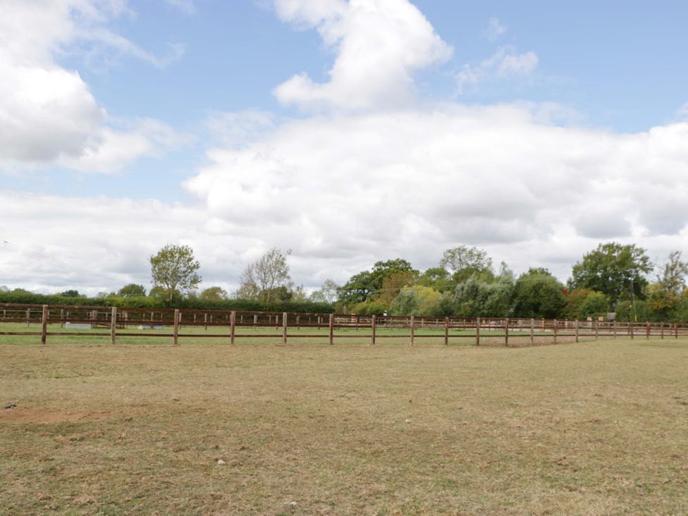 A fenced area with grass and trees at Bell 1 Shades Farm near Malmesbury