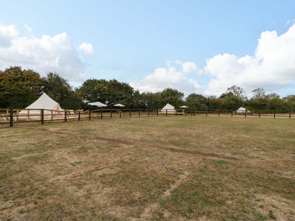 An outdoor area with tents and a wooden fence at Bell 1 near Shades Farm near Malmesbury