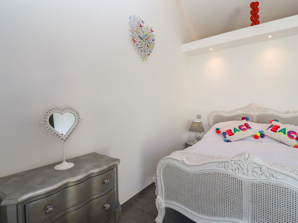 A bedroom with a bed, dresser, and mirror at Noflash Malpal in Bristol