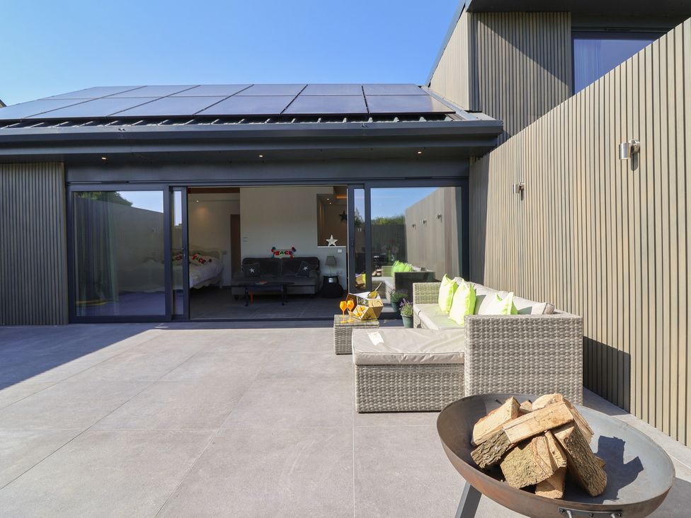 An outdoor patio with seating and a fire pit at Noflash Malpal in Bristol