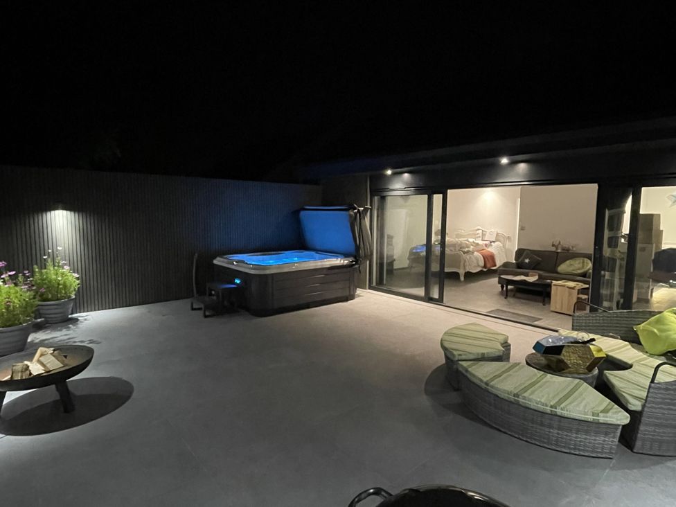 A garden area with a hot tub and outdoor seating at Noflash Malpal Bishop Sutton