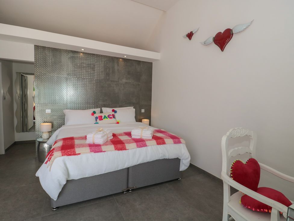 A bedroom with a bed and chair at Noflash Malpal in Bishop Sutton