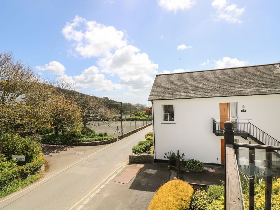 A view of a building and road with trees at Tater-Du in Porthcurno