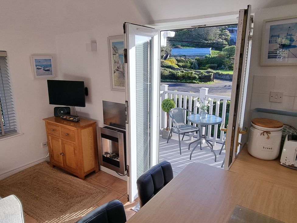 A living room with a television and a fireplace at Tater-Du in Porthcurno near Land’s End