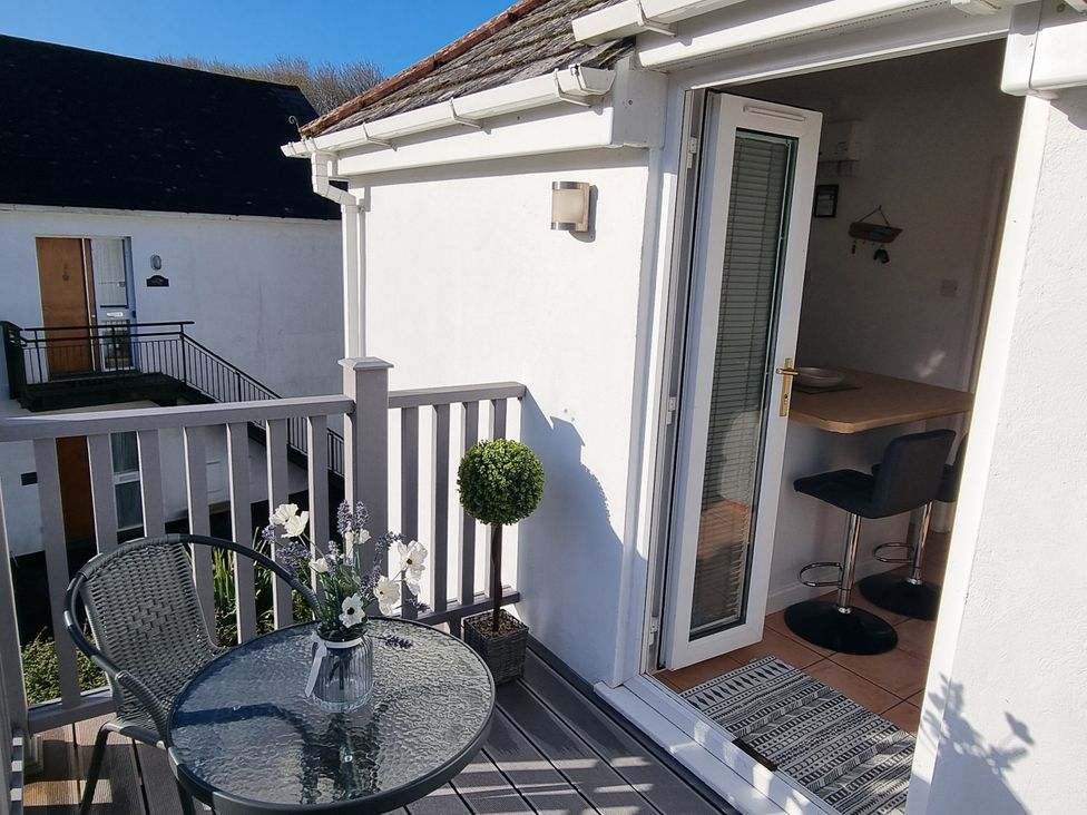 A balcony with table and chairs at Tater-Du in Porthcurno near Land’s End