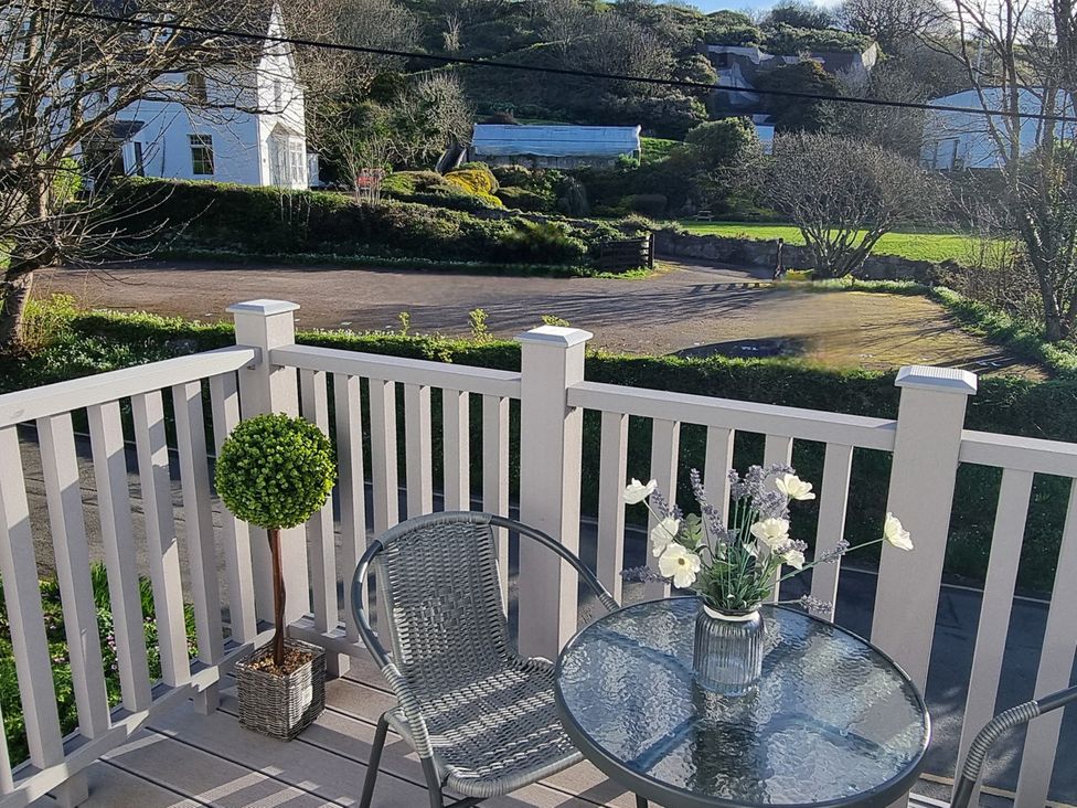 A balcony with a table and chair at Tater-Du in Porthcurno near Land’s End