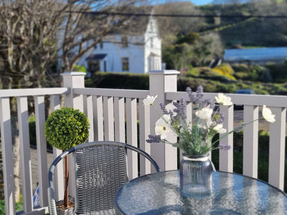 An outdoor space with a table and chair at Tater-Du in Porthcurno near Land’s End