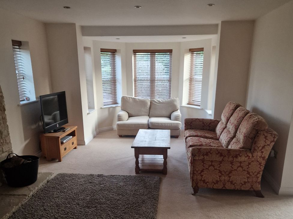 A living room with a sofa and armchair at The Mill House in Glastonbury