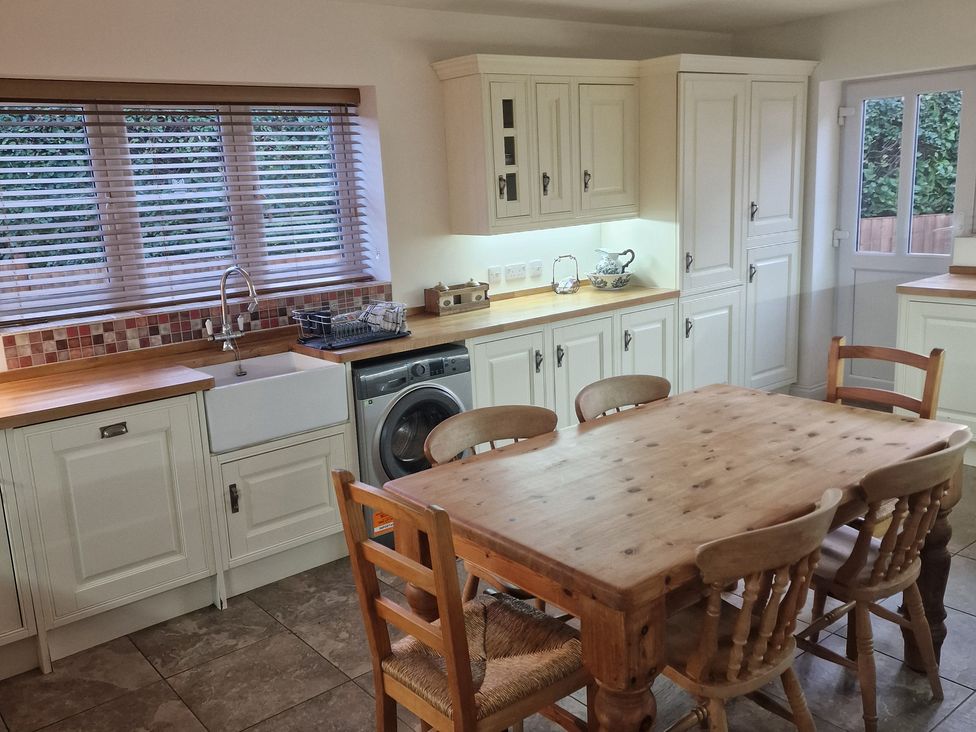 A kitchen with a dining table and kitchen sink at The Mill House in Glastonbury