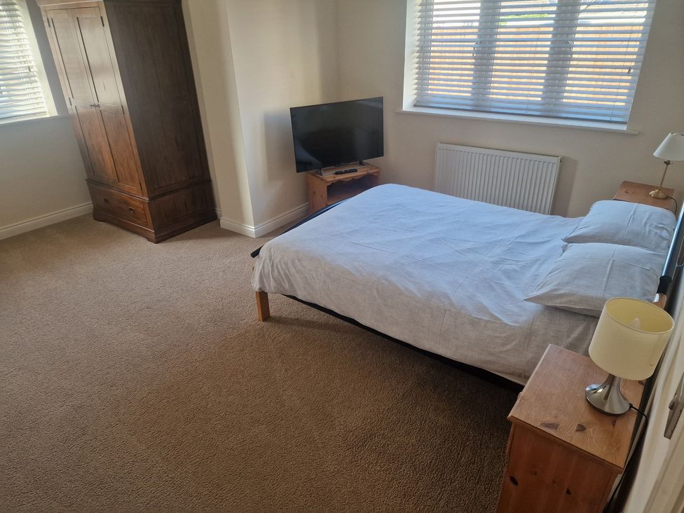 A bedroom with a bed and wardrobe at The Mill House in Glastonbury