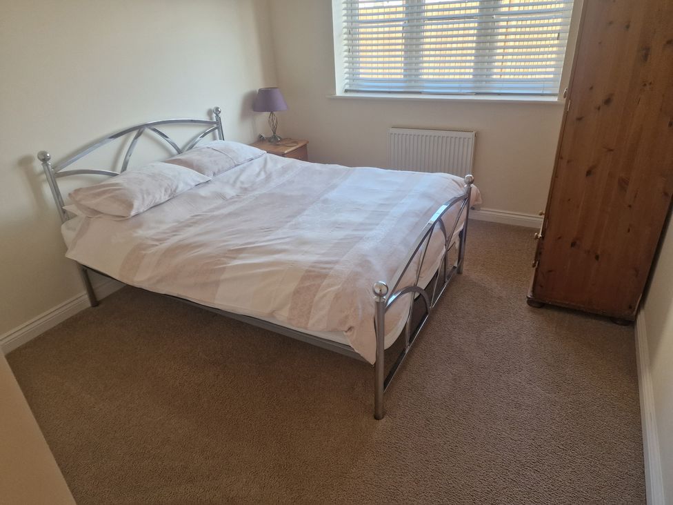 A bedroom with a bed and a wardrobe at The Mill House in Glastonbury