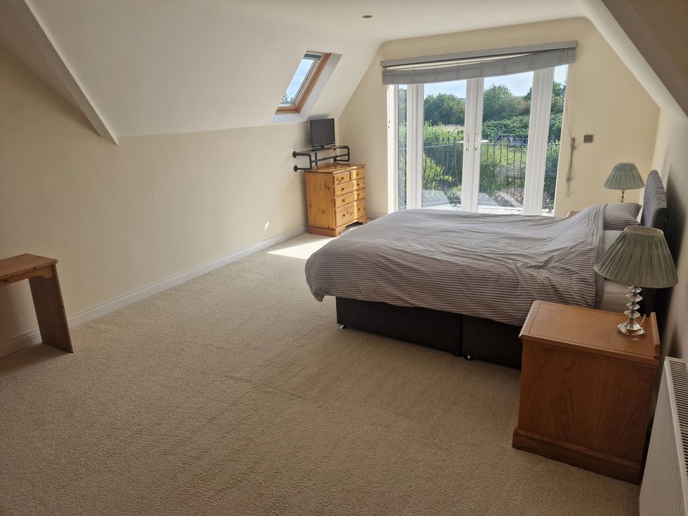 A bedroom with a bed and a dresser at The Mill House in Glastonbury