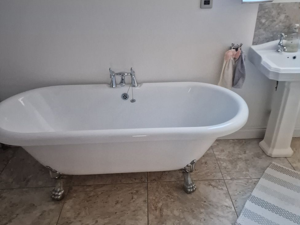 A bathroom with a bathtub and sink at The Mill House in Glastonbury