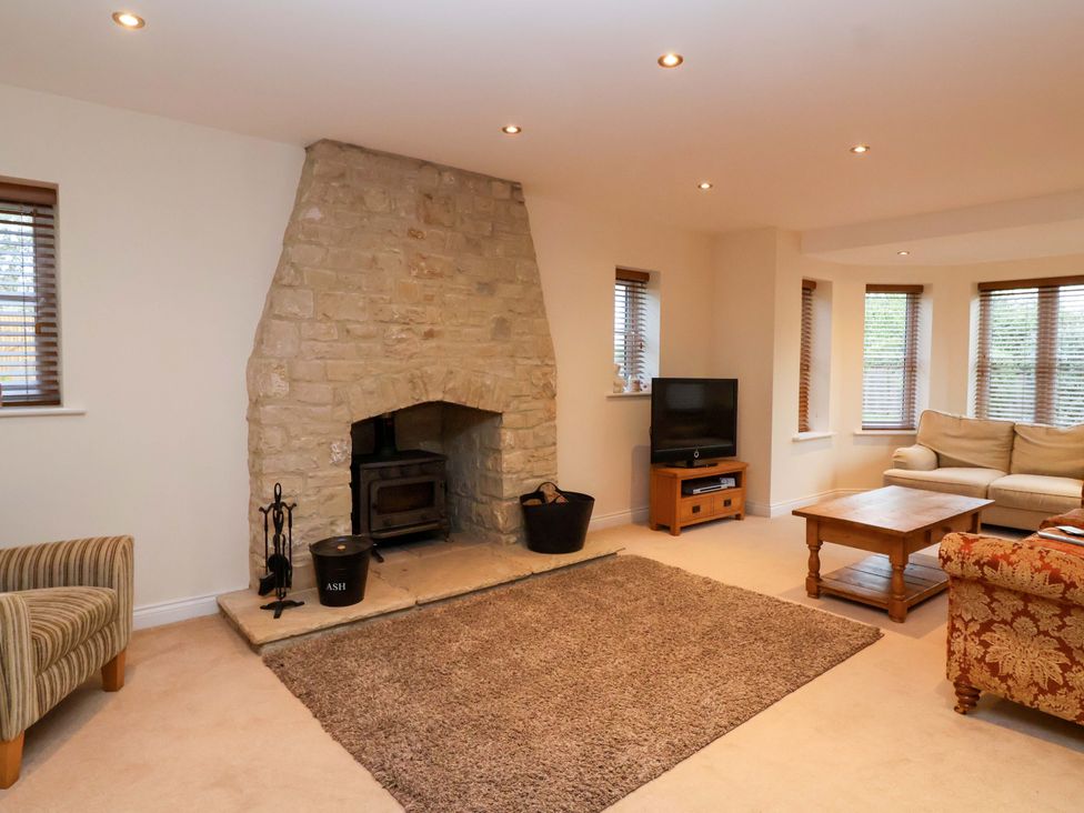 A living room with a fireplace and sofa at The Mill House in Glastonbury