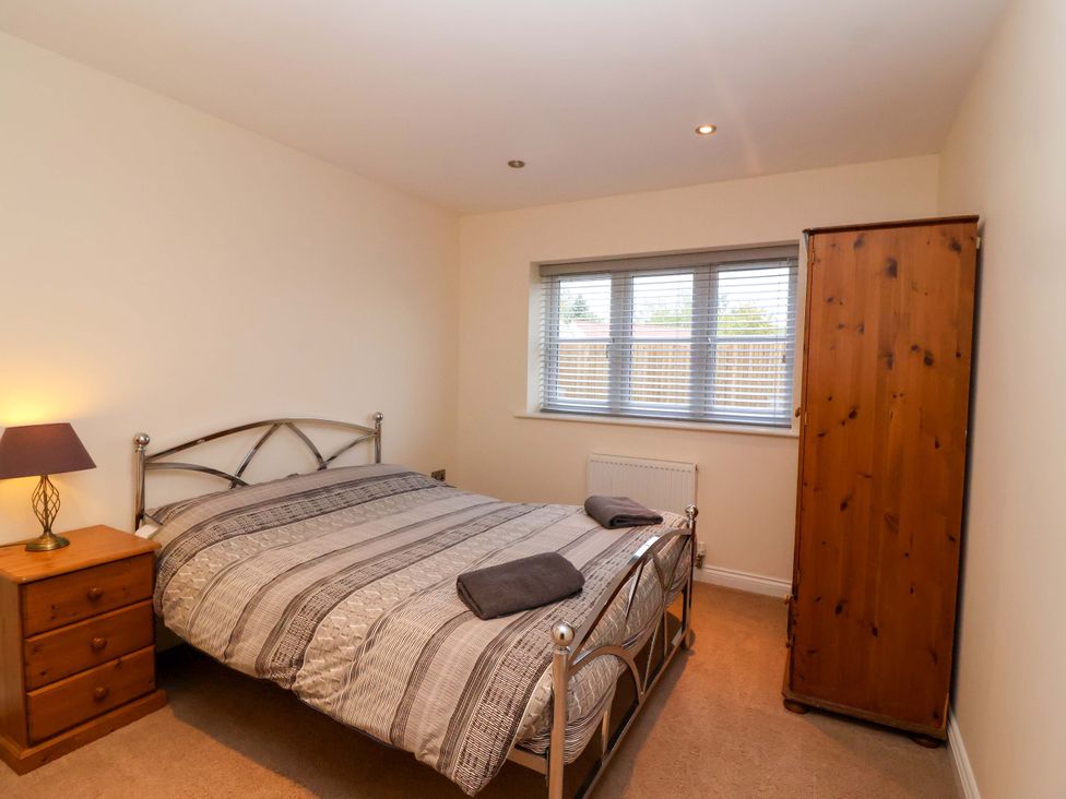 A bedroom with a bed and nightstand at The Mill House in Glastonbury