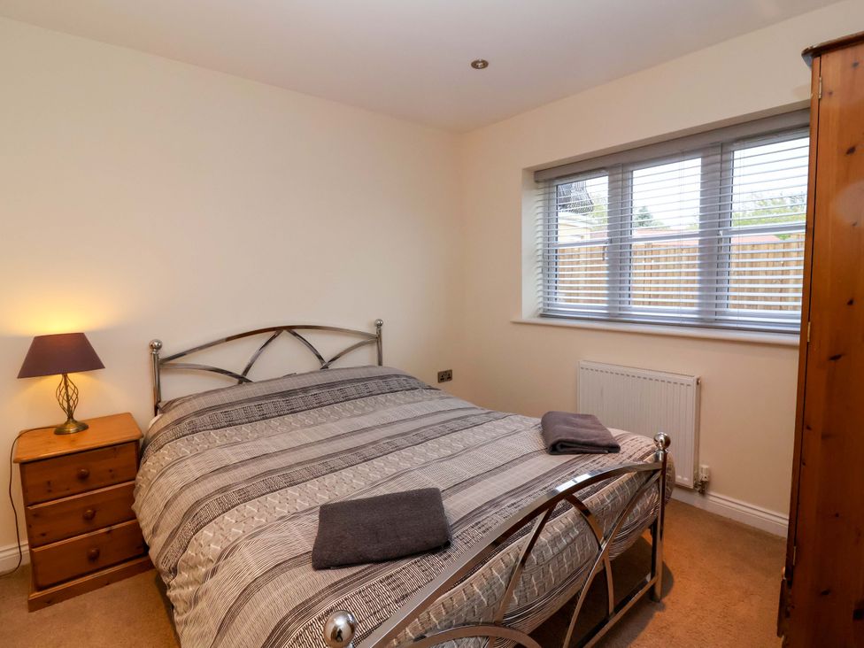 A bedroom with a bed and bedside table at The Mill House in Glastonbury
