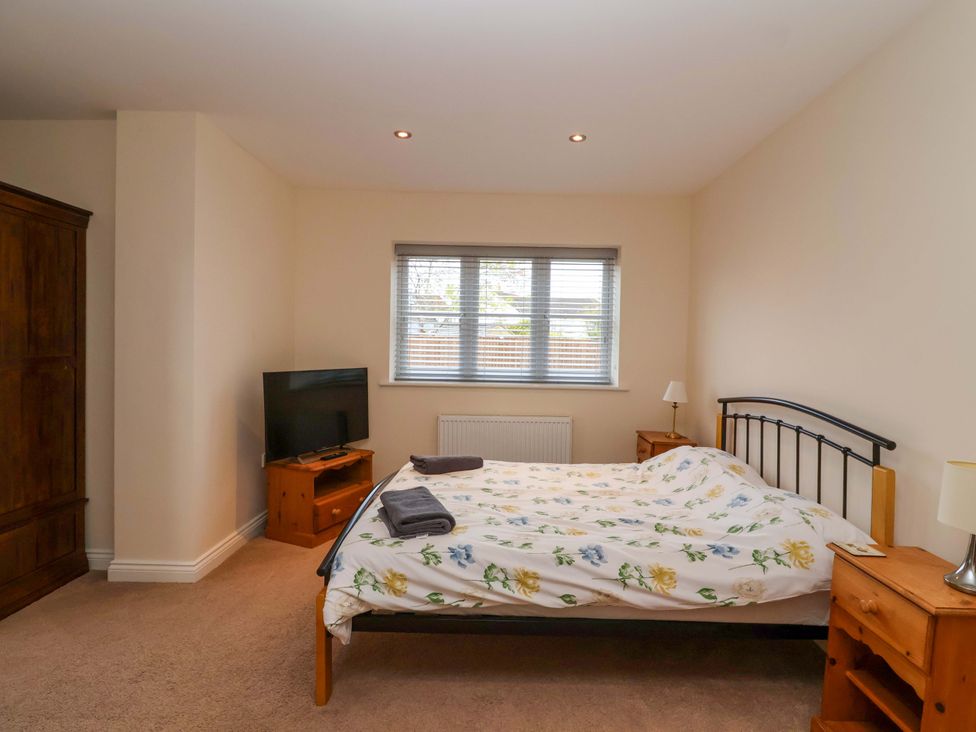 A bedroom with a bed and wardrobe at The Mill House in Glastonbury