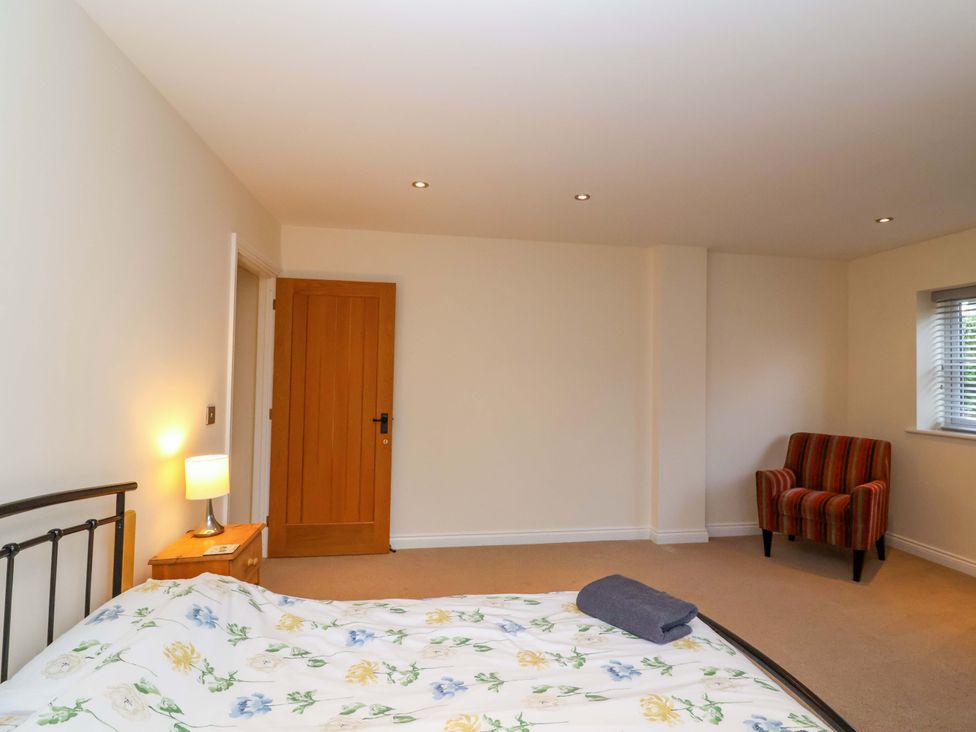 A bedroom with a bed and nightstand at The Mill House in Glastonbury