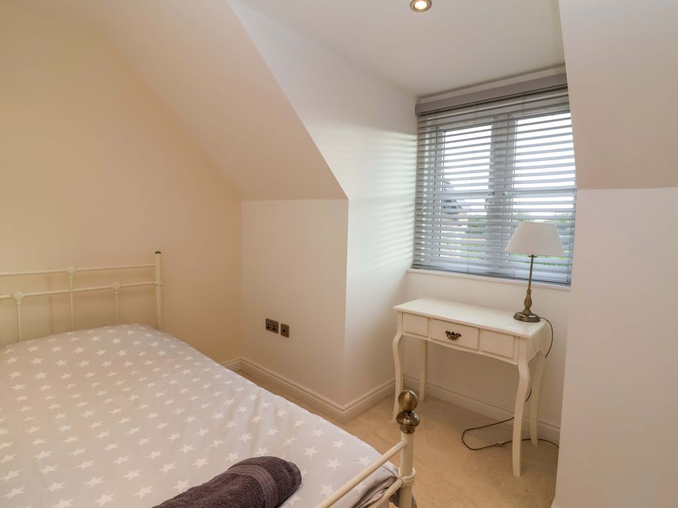 A bedroom with a bed and a desk at The Mill House in Glastonbury