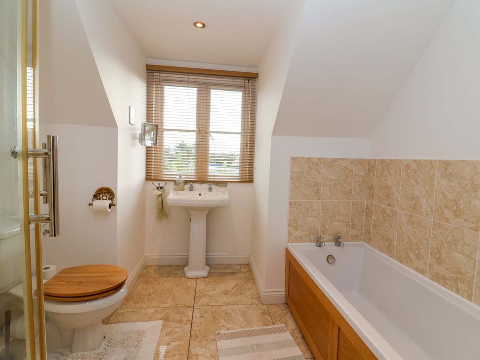 A bathroom with a bathtub and sink at The Mill House in Glastonbury