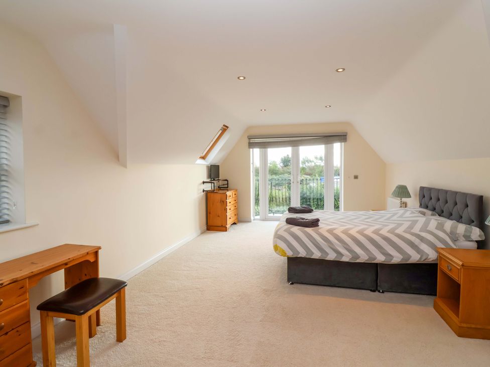 A bedroom with a bed and desk at The Mill House in Glastonbury