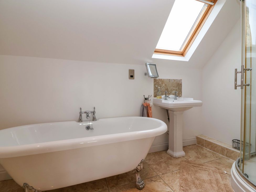 A bathroom with a bathtub and sink at The Mill House in Glastonbury