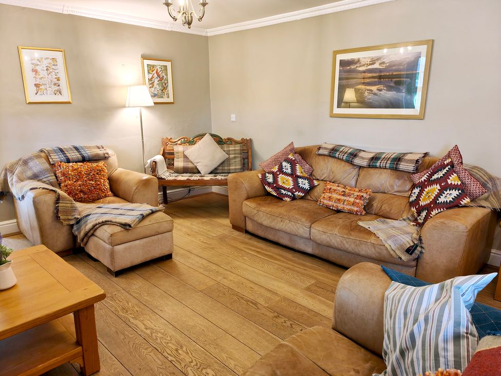 A living room with sofas and coffee table at Bush Nook House in Brampton