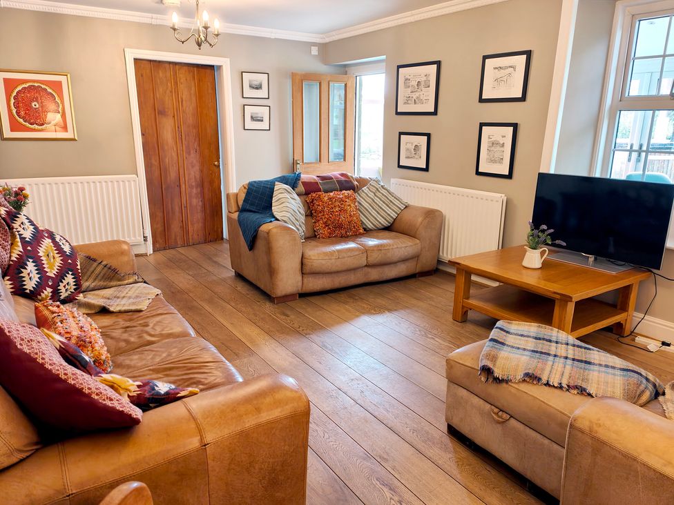 A living room with sofas, a coffee table and a television at Bush Nook House in Brampton