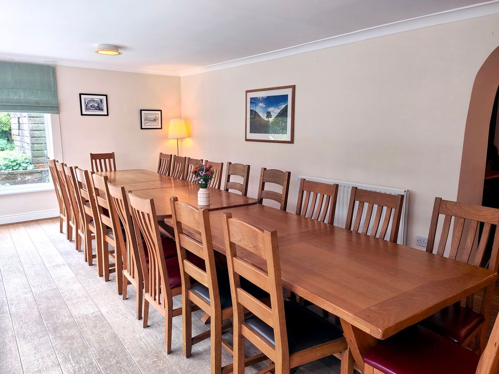 A dining room with a long table and chairs at Bush Nook House in Brampton