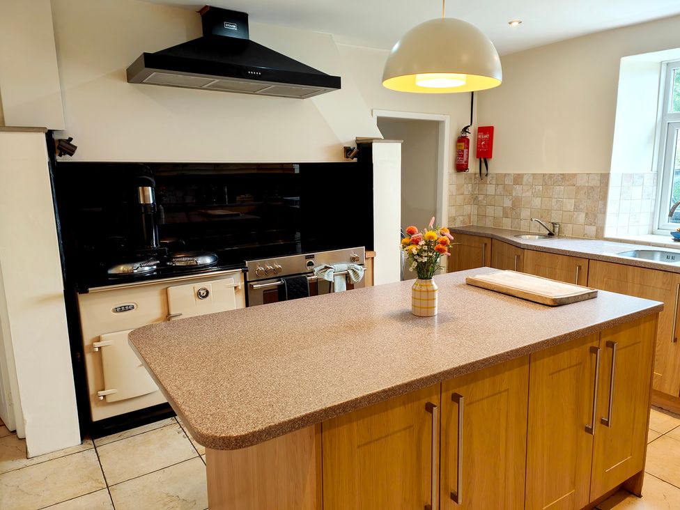A kitchen featuring an island, oven, and sink at Bush Nook House in Brampton